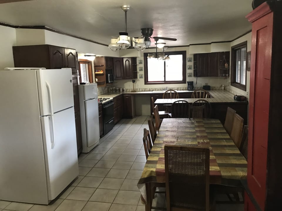 Kitchen seats 14  with 3 refrigerators and 6 burner stove. 