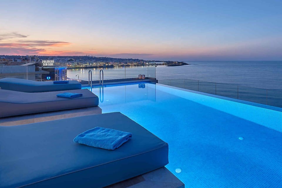 sunset and citylight of Hersonissos with breathtaking news at infinitypool