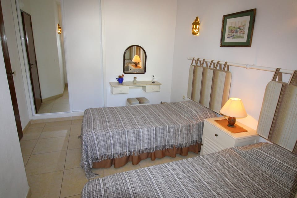 Twin Bedroom beside main bathroom has mirrored wardrobe .