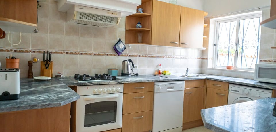 Well-equipped kitchen has all appliances and and a pantry.