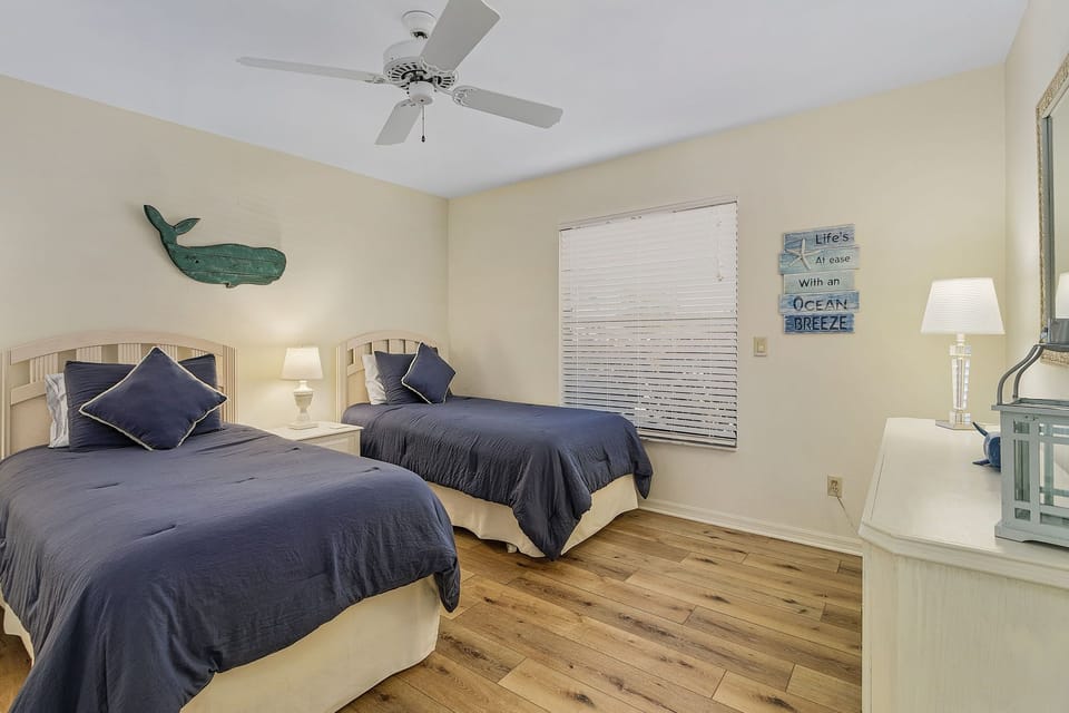 Bedroom 3 has 2 twin beds, dresser, closet and coastal decor