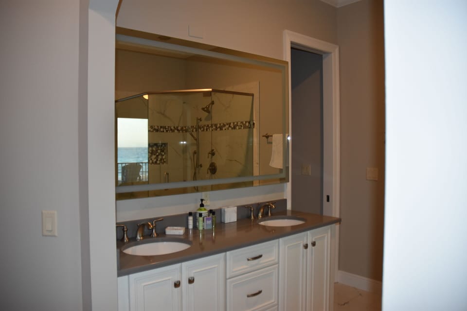 Large lighted mirror with double sink vanity in the master bath.
