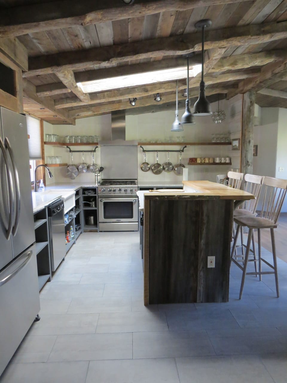The kitchen has a large refrigerator freezer and 5 burner commercial grade stove