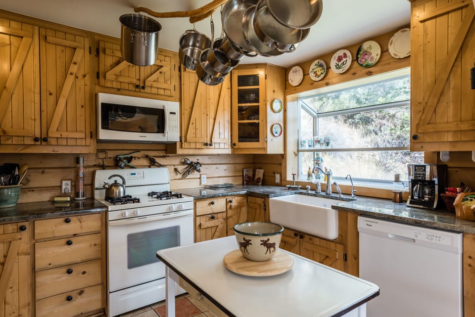 The kitchen has a garden window, farm sink, and modern appliances.