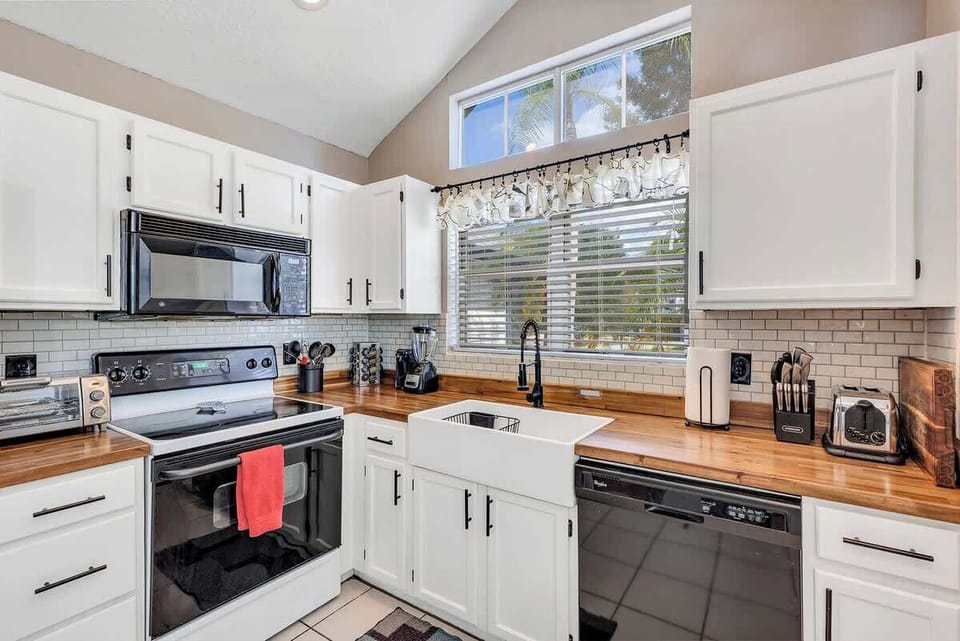 Newly renovated farmhouse kitchen complete with butcher block counter tops, white farmhouse sink, breakfast nook, Keurig Duo coffee & k-cup machine, tea kettle, coffee bar and fully stocked with plates, bowls, cups, utensils, appliances & pots/pans!