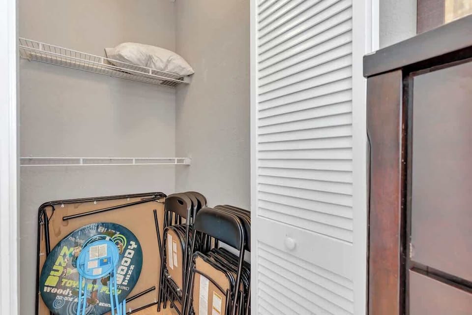 Bedroom 4 closet with 1 buzz lightyear kids table, 3 black standard card tables with extra chairs.