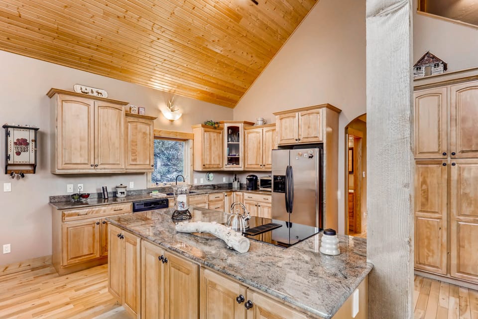 The luxurious well-appointed kitchen has custom cabinetry and counter tops. It is spacious with new stainless appliances.