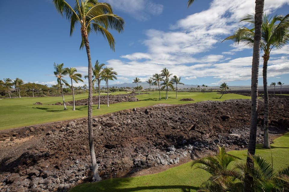 Enjoy iconic Mauna Lani golf course views, framed by palm trees and ancient lava rock.