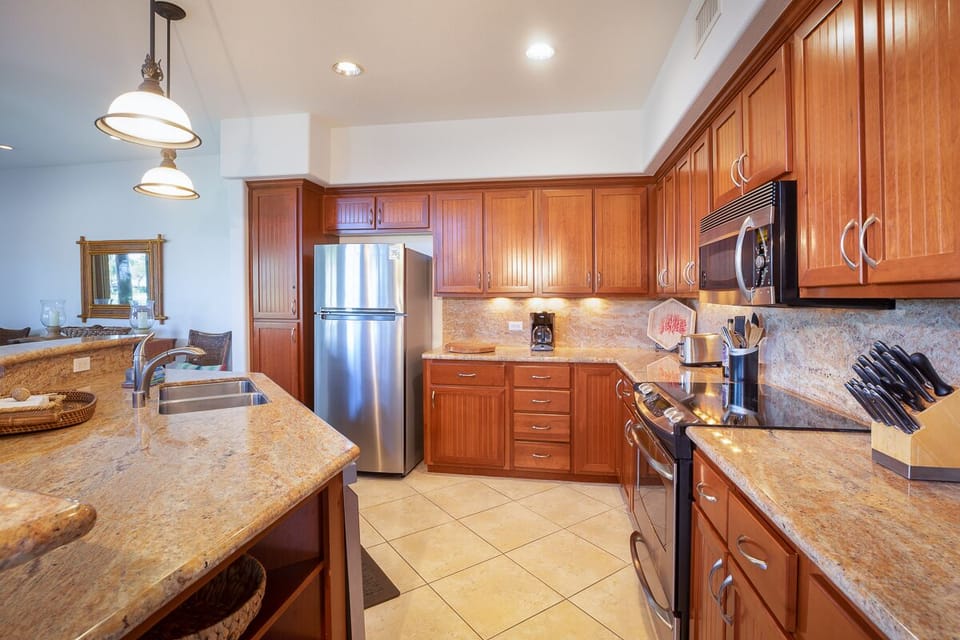 Fully stocked kitchen with granite countertops and warm wood cabinetry for all your culinary needs.