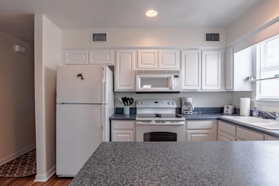 cute white kitchen, fridge with icemaker, smoothtop stove, microwave, dishwasher
