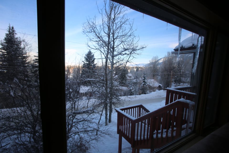 Looking out of living room onto town and front entrance stairs.