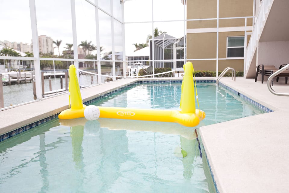 View of Volley ball net in pool. There are also plenty of pool toys and floats. 