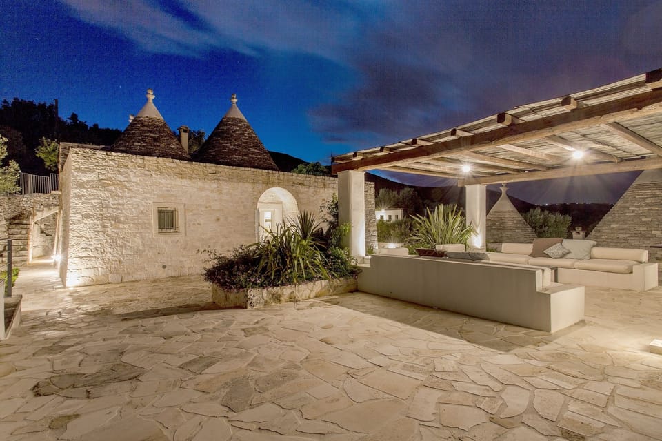 Night view of external lounge and trullo