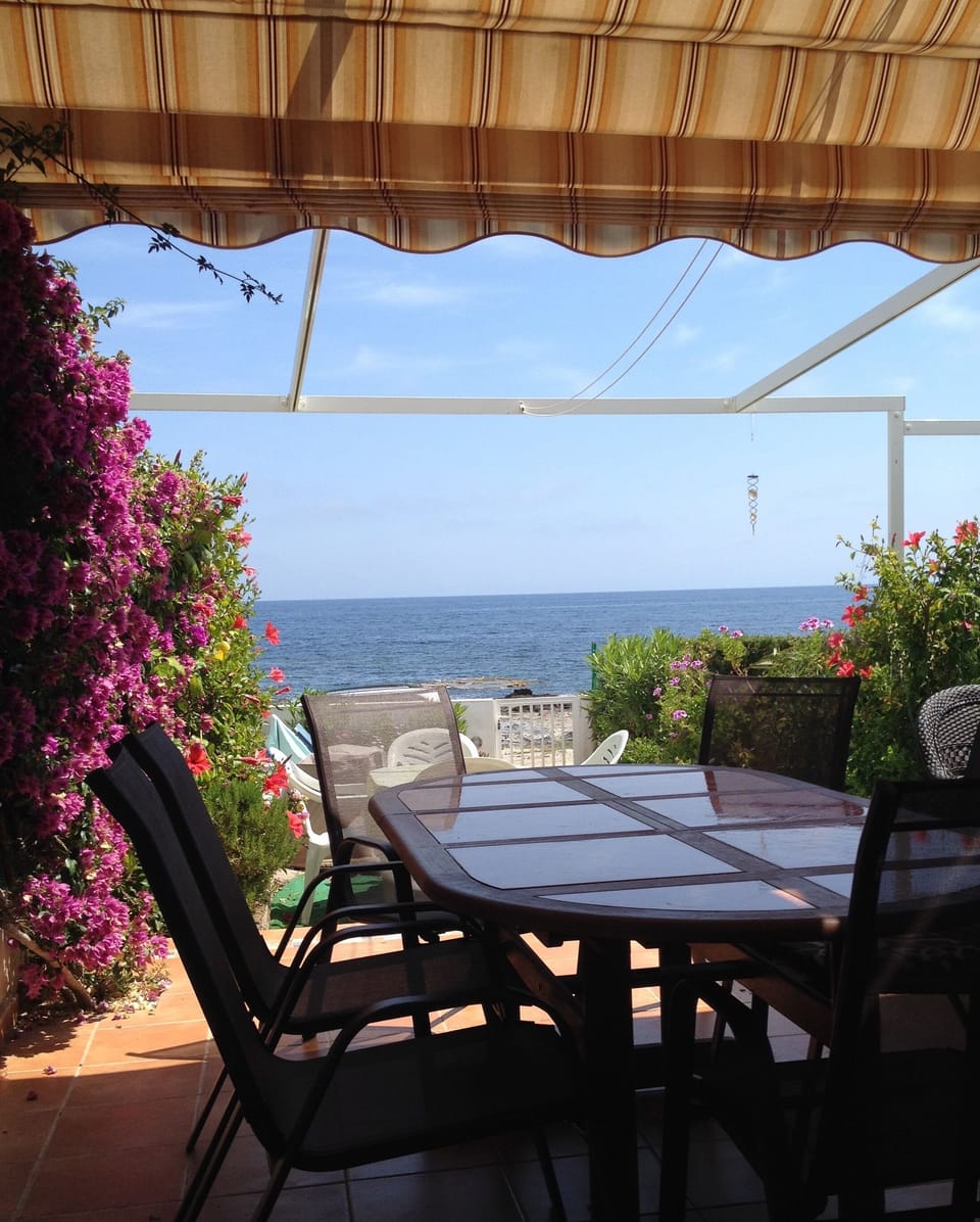 Overlooking sea, back garden, with awning, large patio eating & sitting areas