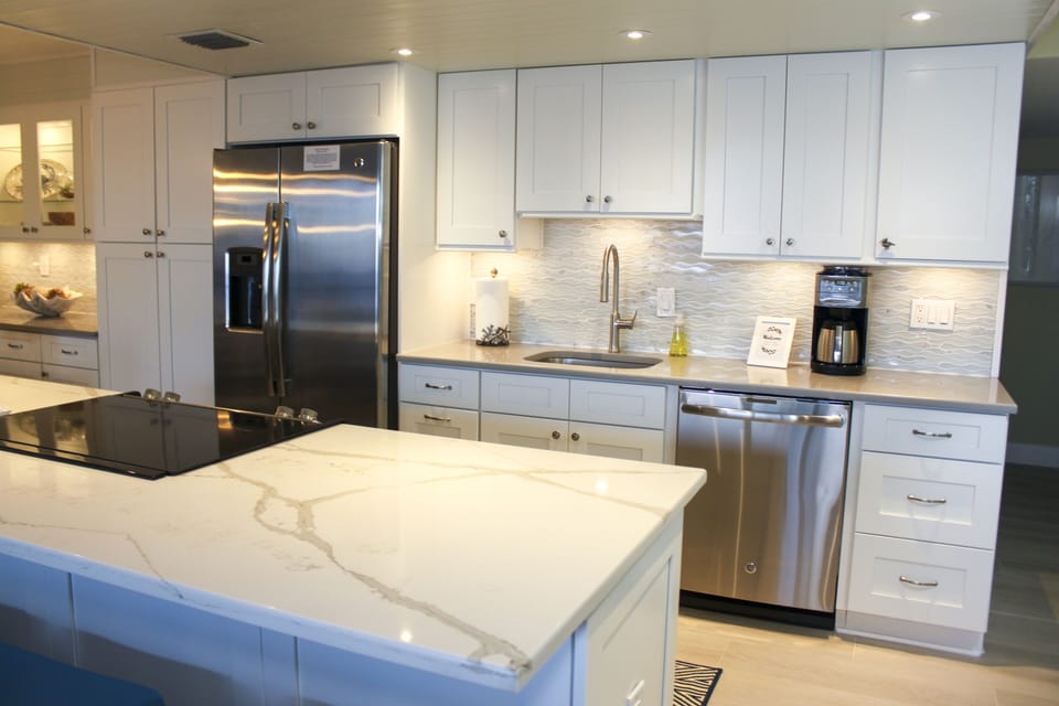 Fully renovated kitchen with quartz countertops and stainless appliances.