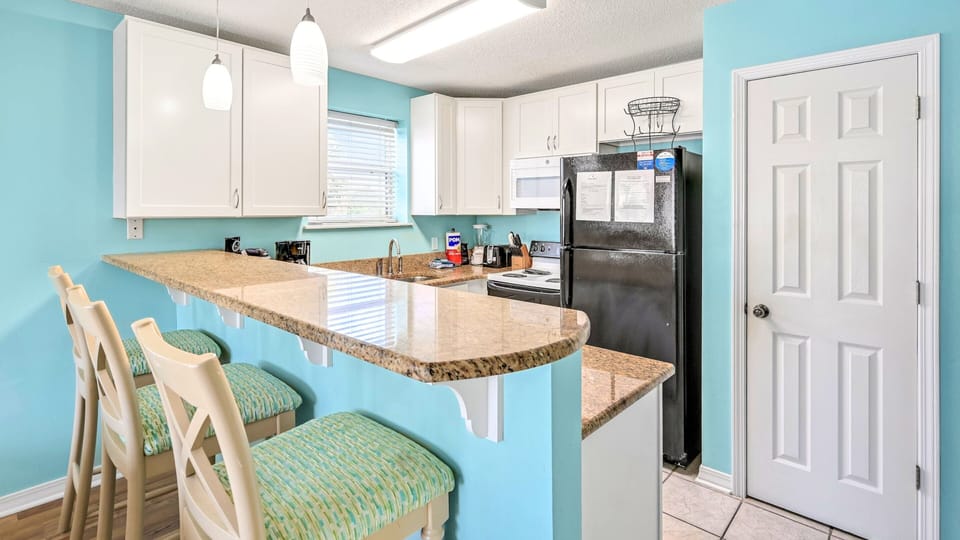 Granite counters, full appliances, and bar seating.