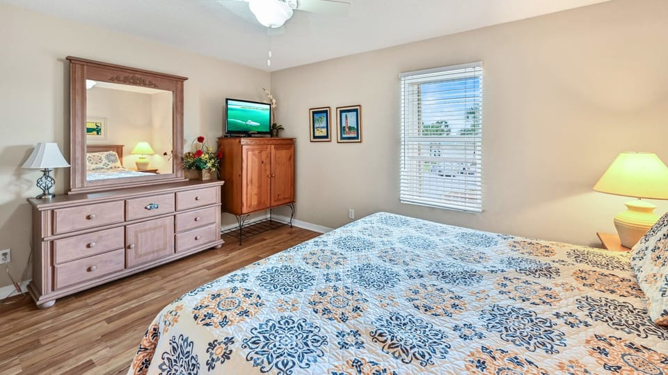 A bright bedroom with a smart TV and cozy bedding.