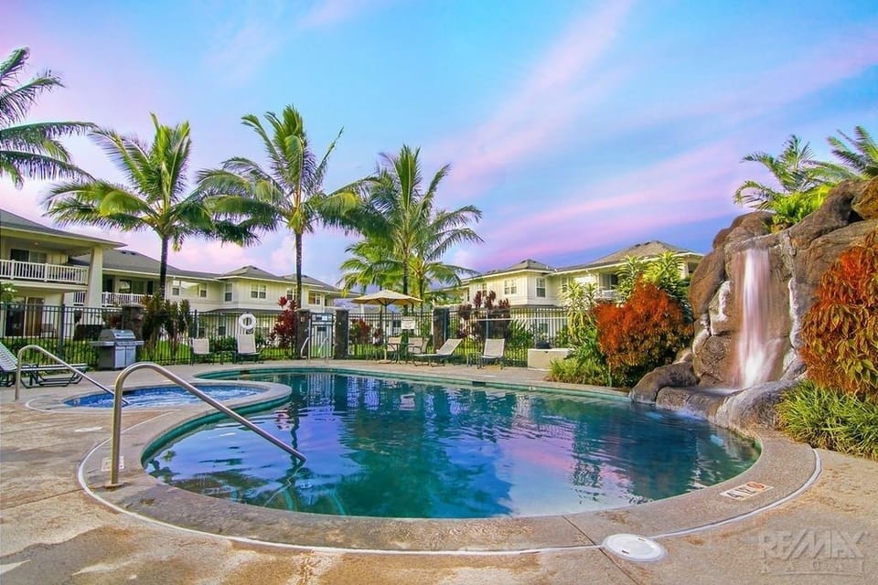 Beautiful pool with waterfall, BBQs, lounge chairs, hot tub, umbrellas