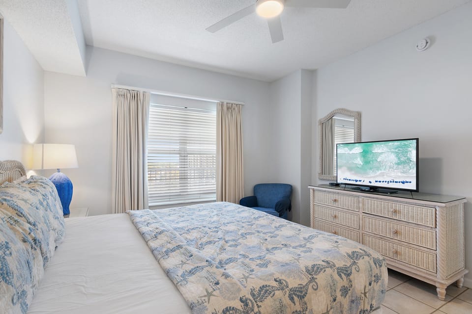 A restful bedroom with a smart TV and cozy bedding.