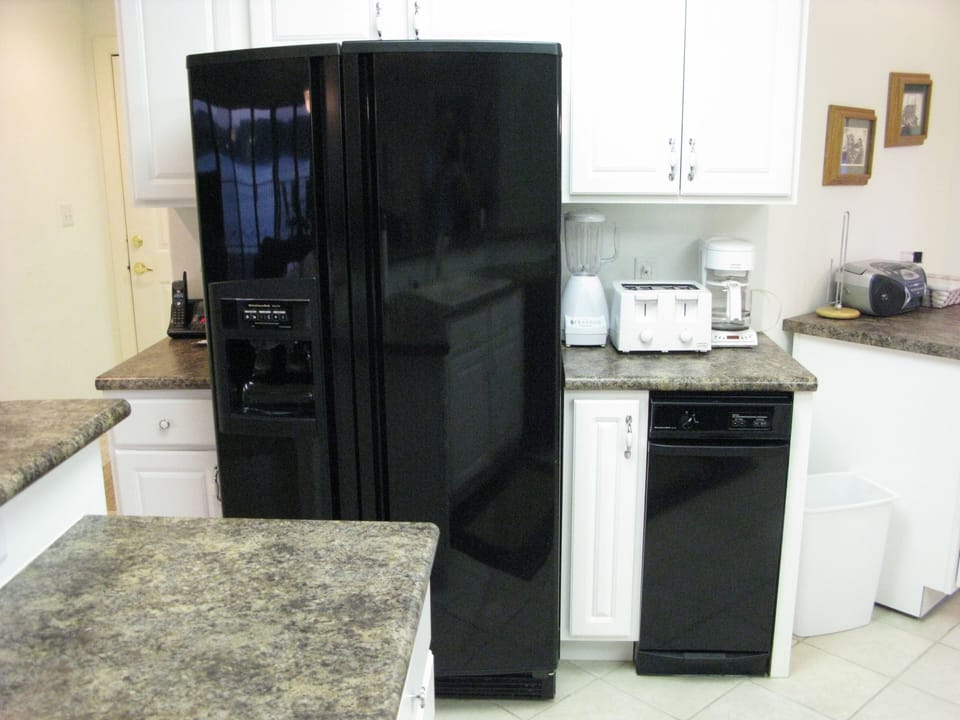 Kitchen's Large Refrigerator, Blender, Toaster, Coffee Maker, & Trash Compactor.