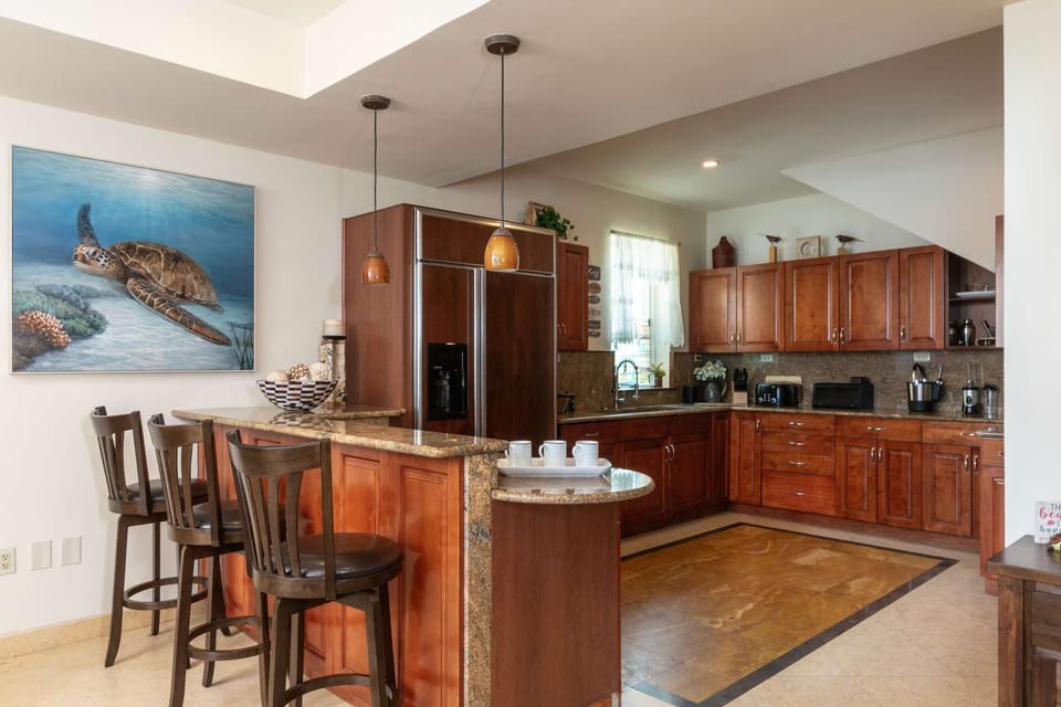 Spacious kitchen with rich wood cabinetry and breakfast bar seating