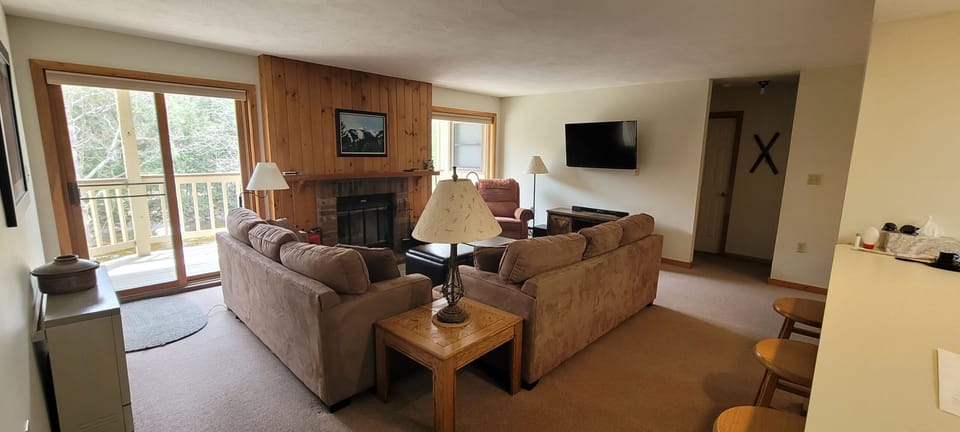 Living Room with a picture window and slider to deck overlooking the river. 