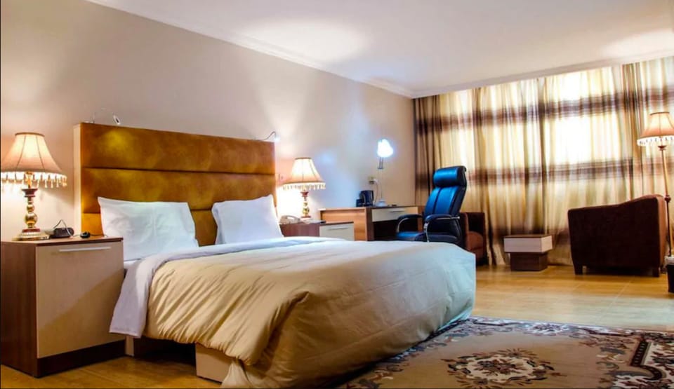 Room (Queens) | Minibar, in-room safe, desk, laptop workspace