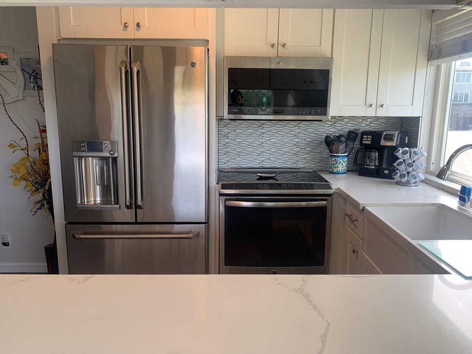 French Door refrigerator, stove-oven combo, Microwave, and dishwasher.