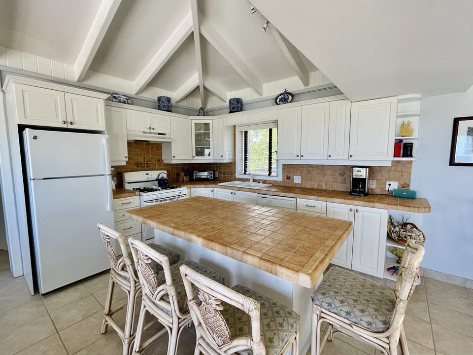 Kitchen with plenty of pots, pans, plates, silverware, and glassware. 