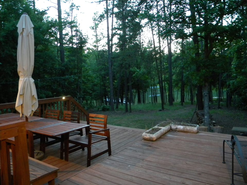 Dine alfresco with seating for 8-10 people under an expansive umbrella