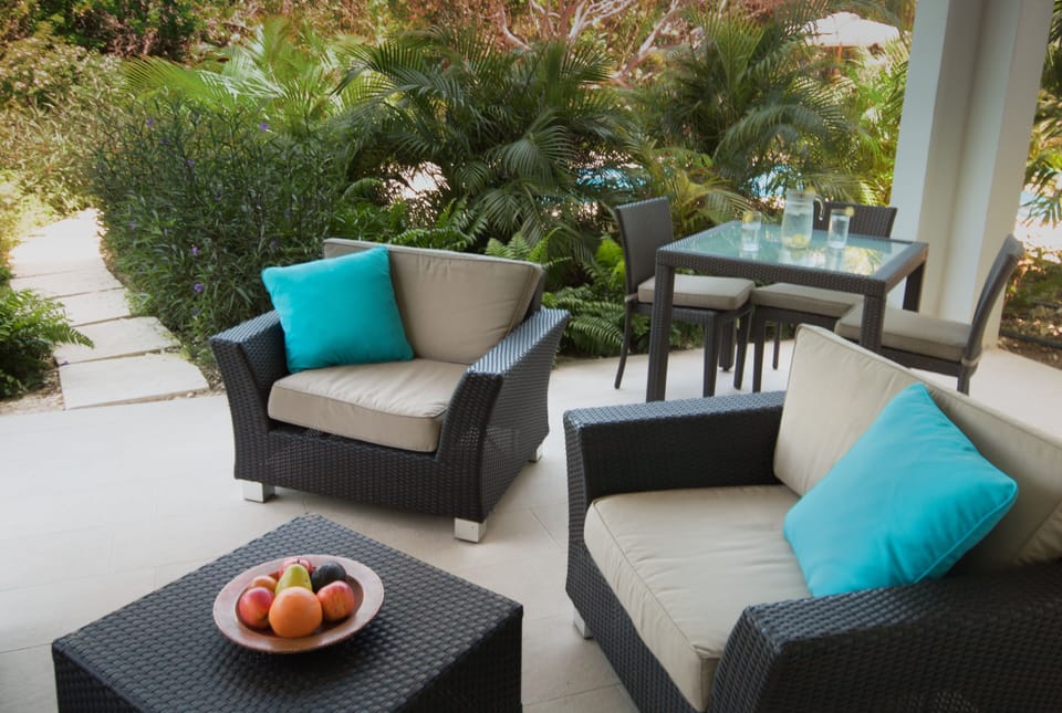 Relish in the tranquility of a covered patio that offers picturesque garden views. This inviting space includes a designated area for dining and seating