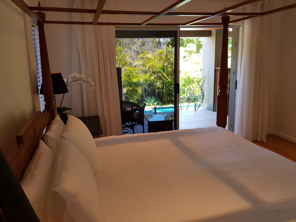 Beautiful main bedroom with own balcony over looking pool and tropical garden.