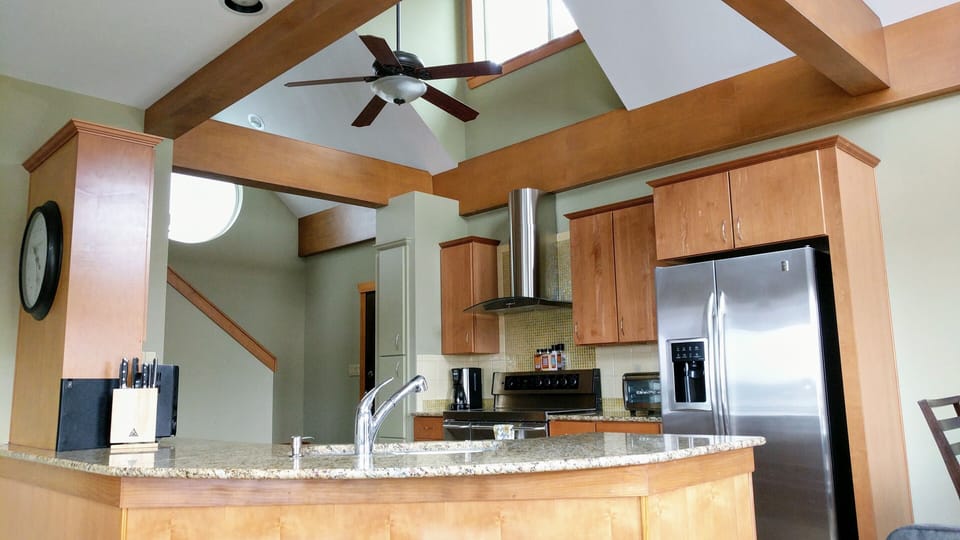 Gourmet kitchen open to living and dining with views out to the lake.