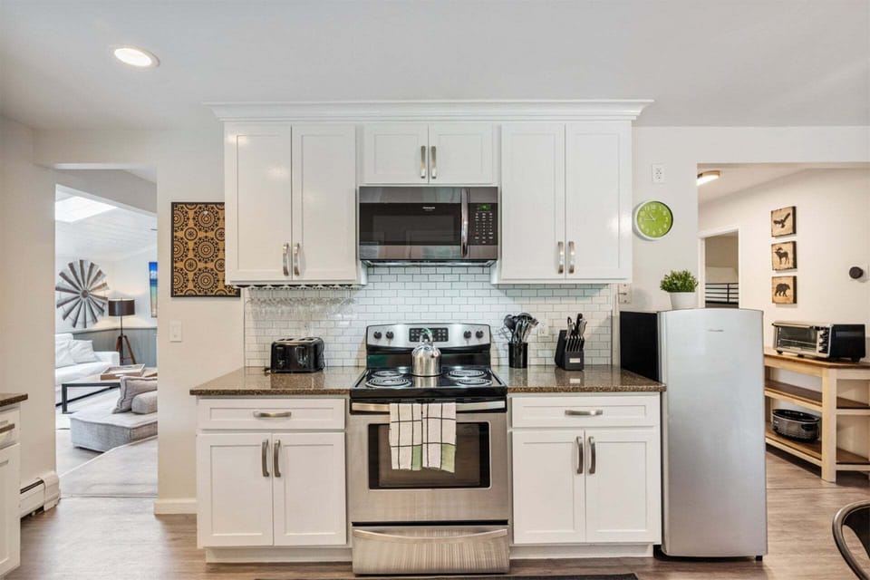 Cook at the range while the living room stays visible through the wide opening.