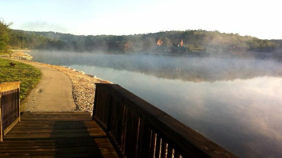 Paved walkway with several foot bridges surrounds Fox Hollow Lake.