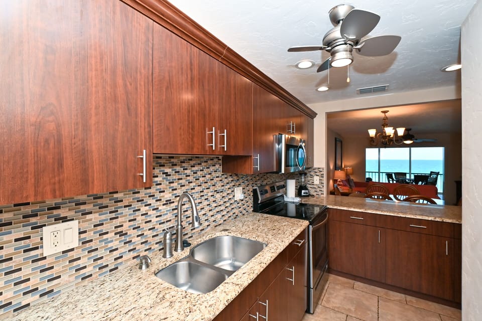 Modern, renovated, fully equipped kitchen with granite counters, glass tile backs splash...