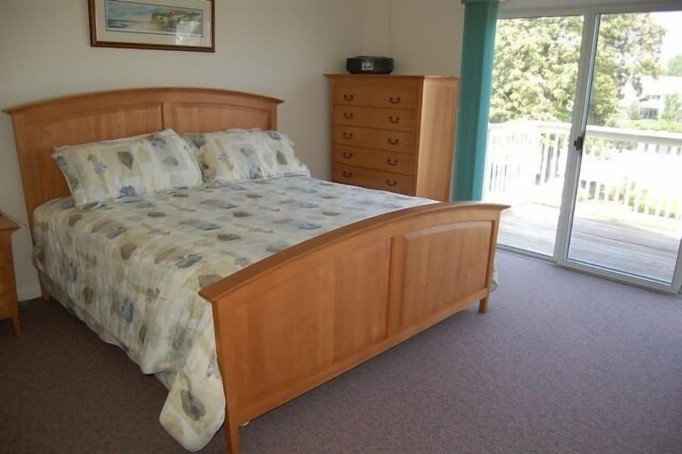 Main bedroom with king bed balcony and connected bath.