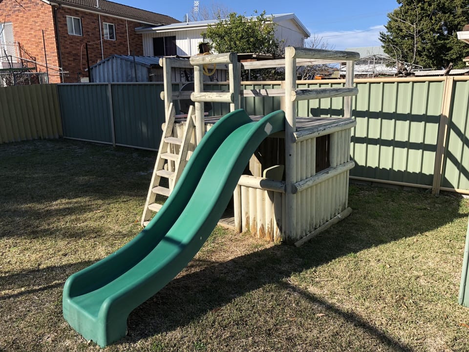 Backyard includes play house with slide