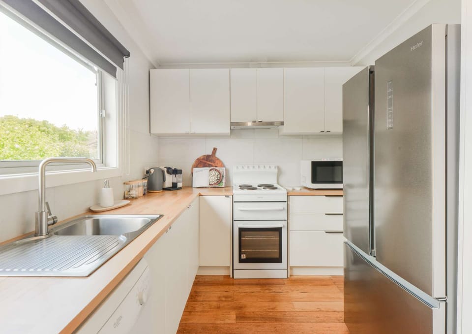 Fully equipped kitchen with oven, stove, microwave, kettle, toaster sand-which press, rice cooker and Nespresso pod coffee machine