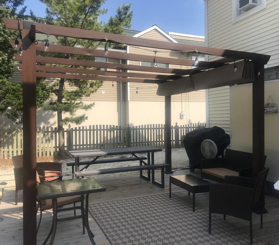 Deck with pergola cover and plenty of seating and gas grill 