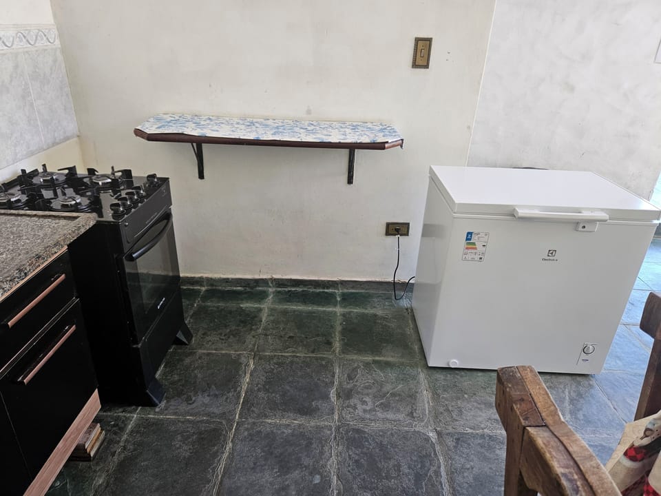 Cozinha com geladeira, gabinete e pia e freezer 200 litros.