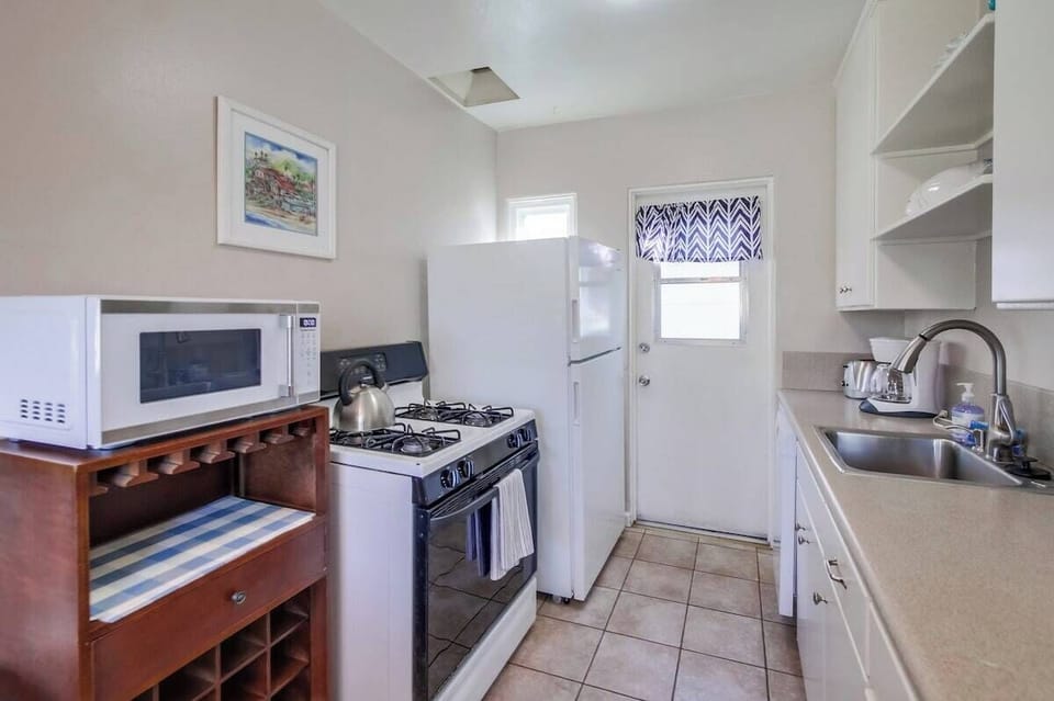 Kitchen with refrigerator, gas stove, microwave, blender, coffee maker, toaster, sink, toaster oven, dishwasher