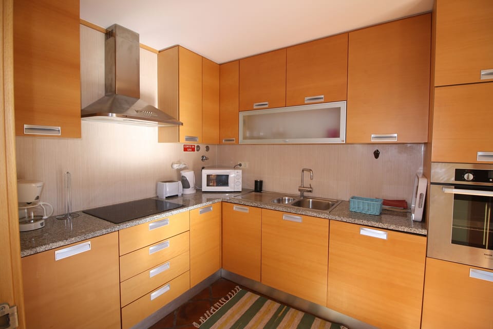 Well-equipped separate kitchen beside the living room has doors to the pool area