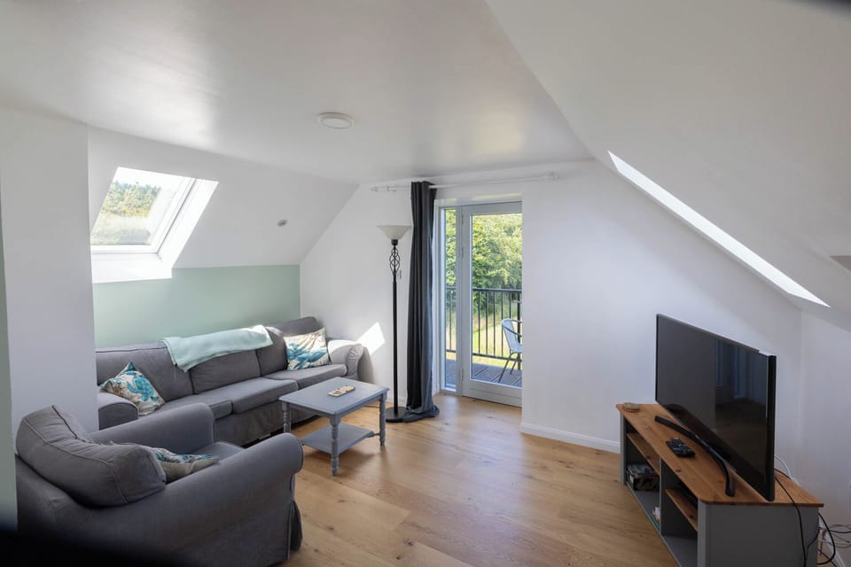 Living room with windows on 3 sides and door opening onto balcony.
