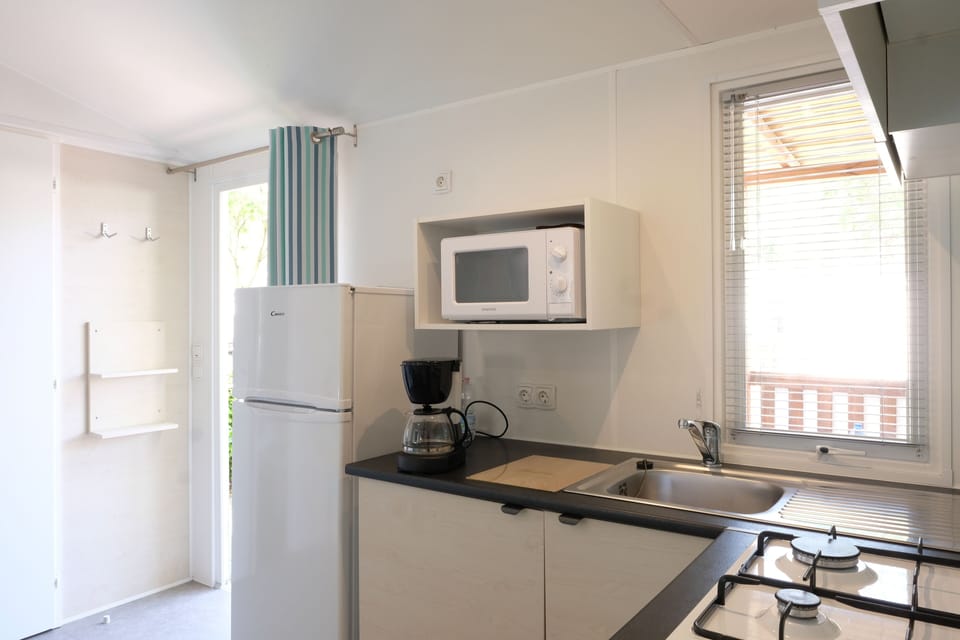 Premium Mobile Home | Private kitchen | Full-size fridge, stovetop, cookware/dishes/utensils, dining tables