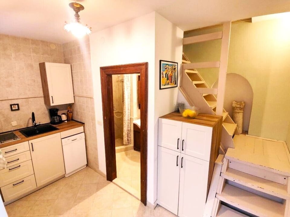 Kitchenette, doorway to bathroom, and steps to bedrooms