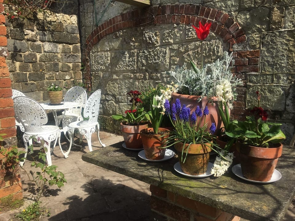 White table and chairs in a sunny spot at the side of the Granary