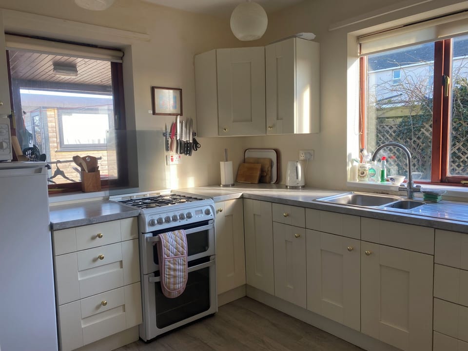 Dual fuel cooker with two ovens. Microwave. Fridge with frozen food compartment.