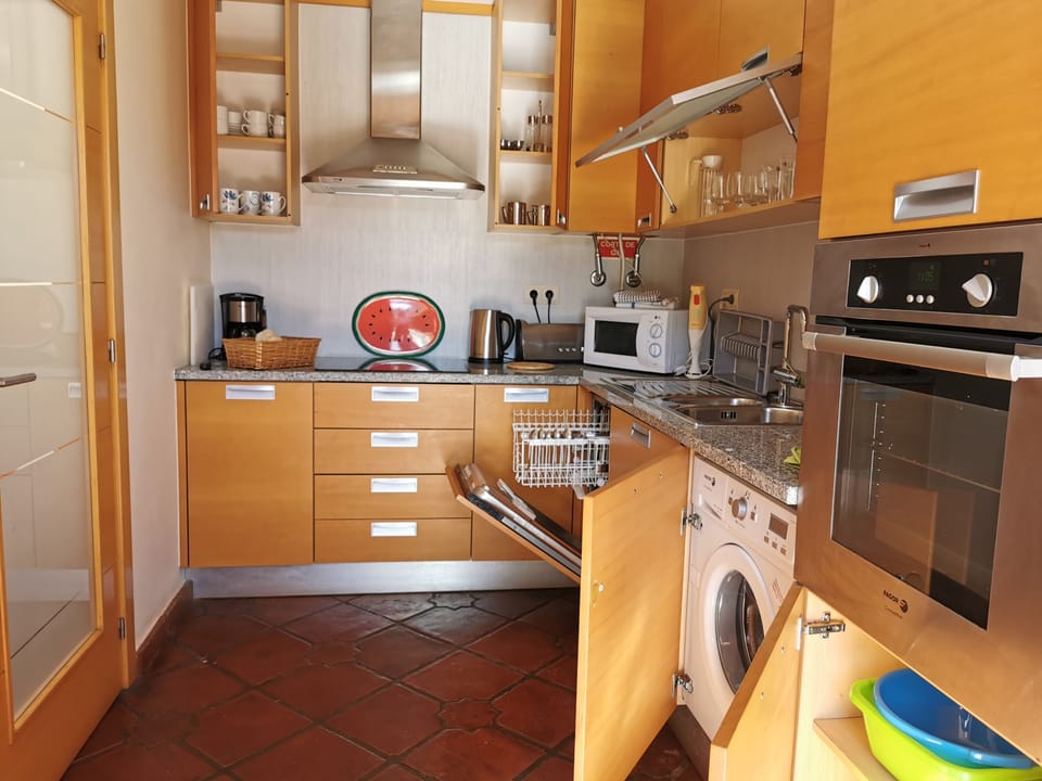 The well equipped kitchen, beside the living room has a door to the pool patio