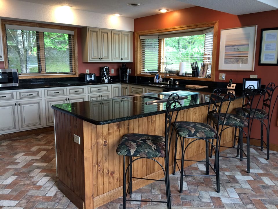 Main floor kitchen with new cabinets, tile floor, granite, and down draft stove.